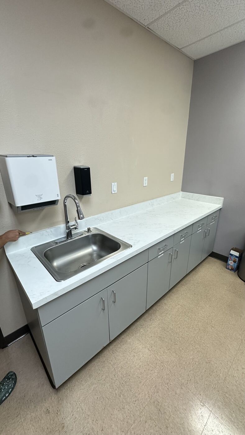 Finished office break-room countertop in white marble-look Bodaq film, wide view