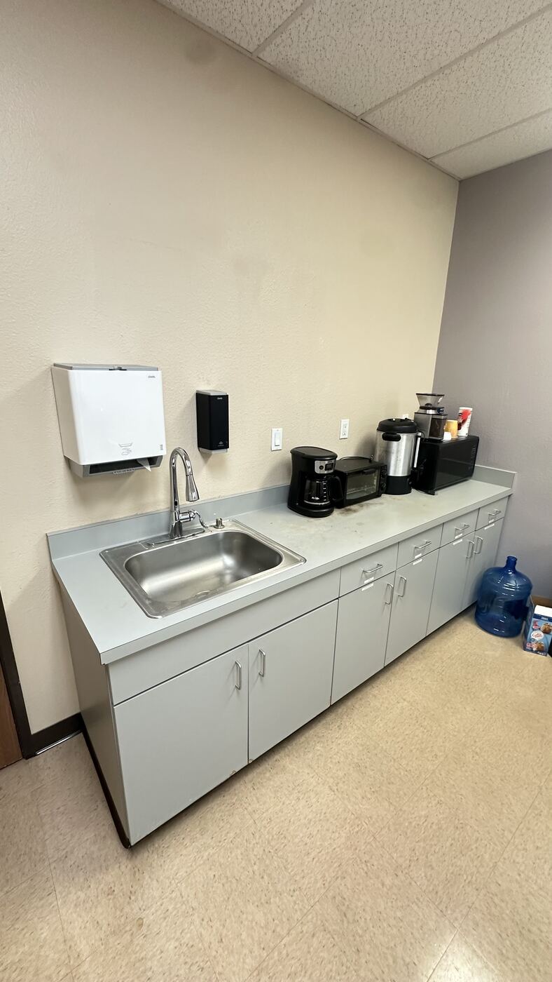 Worn gray laminate office break-room countertop before Bodaq film