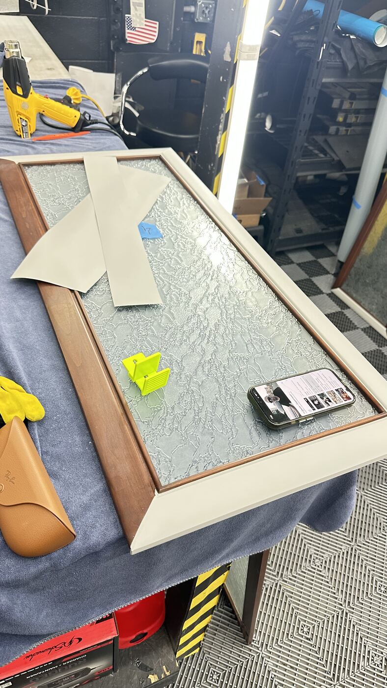 Textured glass cabinet door being prepped on a workbench